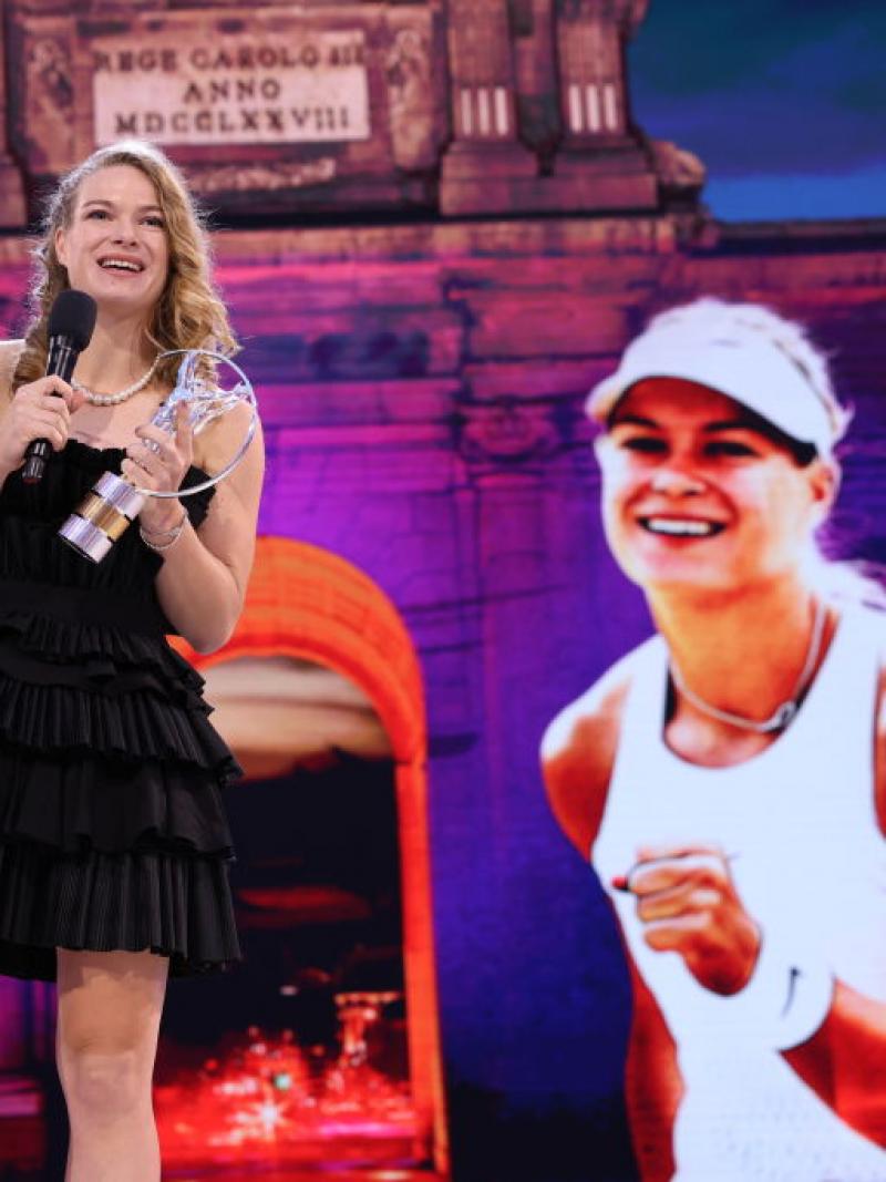 A female athlete makes a speech on a stage.